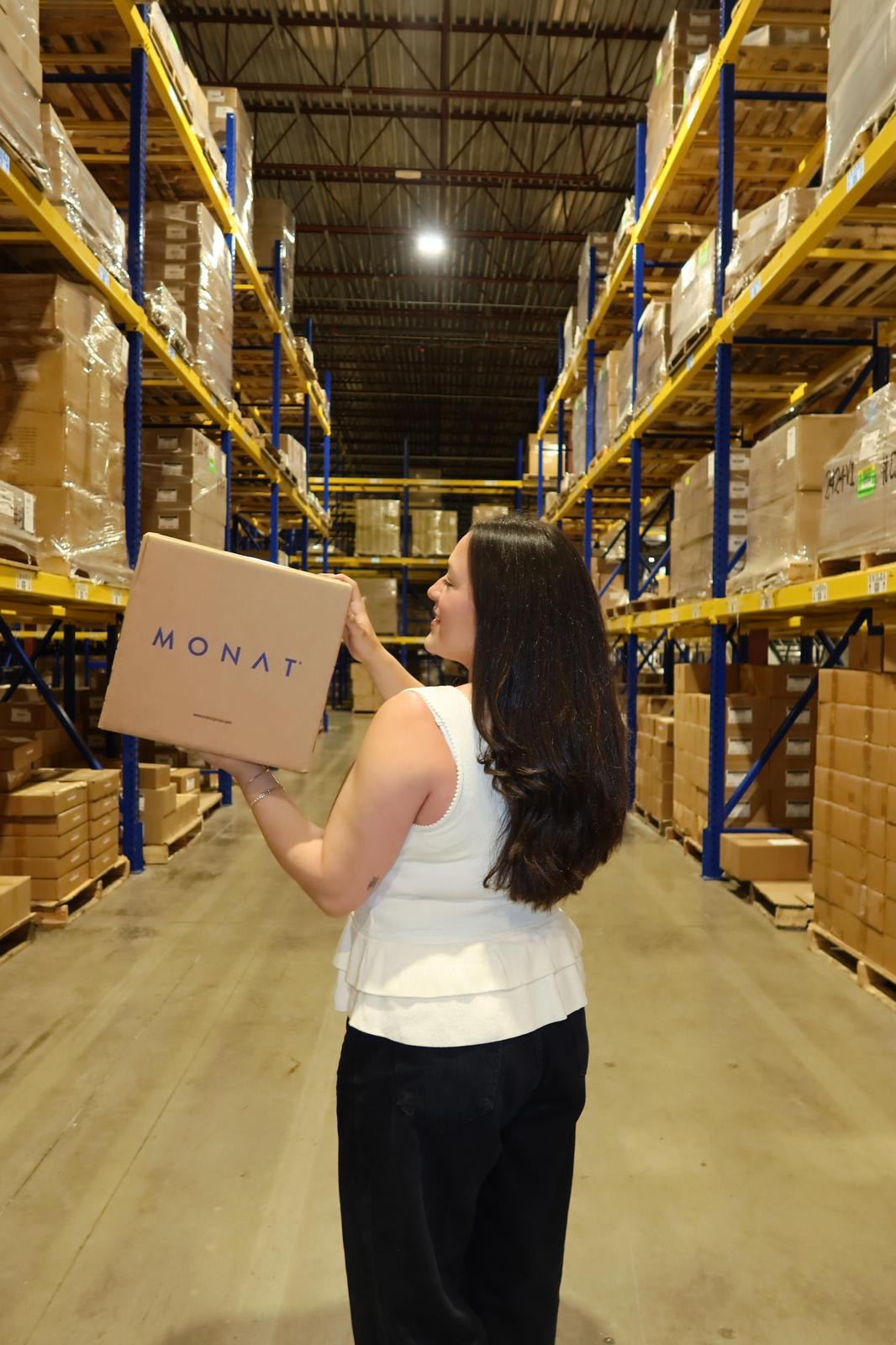Barbara Pineda de espaldas examinando caja MONAT